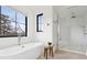 Bright bathroom featuring a soaking tub next to a window and glass-enclosed shower at 815 E Westglow Ln, Greenwood Village, CO 80121