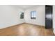 Minimalist bedroom with hardwood floors, two windows, and a black door, bright interior at 815 E Westglow Ln, Greenwood Village, CO 80121