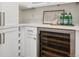 Modern wine storage with temperature control is surrounded by white cabinetry and countertop at 815 E Westglow Ln, Greenwood Village, CO 80121