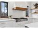 Modern kitchen with Miele stainless steel range, white cabinets and a custom wood range hood at 815 E Westglow Ln, Greenwood Village, CO 80121