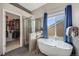 Bathroom featuring a modern soaking tub, tiled shower, and walk-in closet at 468 Sylvestor Trl, Highlands Ranch, CO 80129