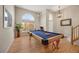 Recreational game room showcasing a pool table, hardwood floors, high ceilings, and abundant natural light at 468 Sylvestor Trl, Highlands Ranch, CO 80129