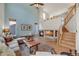 Bright living room boasts vaulted ceilings, a cozy fireplace, hardwood floors, and staircase leading up to the second story at 468 Sylvestor Trl, Highlands Ranch, CO 80129