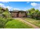 Spacious backyard with a brick patio, green lawn, and mature landscaping at 346 N Corona St, Denver, CO 80218