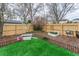 Fenced backyard featuring a grass area, raised garden beds, and a fire hydrant decoration at 2225 Clayton Cir, Superior, CO 80027