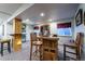 Open basement with bar and barstool seating, wood cabinet and table with chairs at 2225 Clayton Cir, Superior, CO 80027