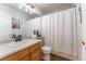 Full bathroom with a wooden vanity, a large mirror, and a shower-tub combo with a white curtain at 2225 Clayton Cir, Superior, CO 80027