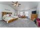 Spacious main bedroom featuring a ceiling fan, large windows, plush carpet, and a decorative headboard at 2225 Clayton Cir, Superior, CO 80027