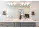 Elegant bathroom with double vanity, sleek countertops, and modern lighting fixtures and decorative flowers at 22 Oneida Ct, Denver, CO 80230