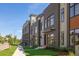 A row of modern townhomes showcases stylish brickwork and a landscaped lawn against a clear blue sky at 22 Oneida Ct, Denver, CO 80230