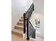 Stylish staircase with dark railing, neutral carpet, and a window view of the neighborhood at 22 Oneida Ct, Denver, CO 80230