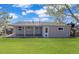 Back exterior of the home with a covered patio, back door, and a lush green lawn at 795 Moline St, Aurora, CO 80010