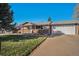 Brick ranch home with attached garage and well-maintained lawn at 8207 Ames Way, Arvada, CO 80003