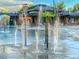 Close up of the community pool splashpad with multiple water features and a nearby clubhouse at 10429 White Pine Dr, Parker, CO 80134