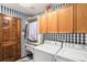 Updated laundry room features a washer, dryer, and built-in storage with stylish wallpaper at 10429 White Pine Dr, Parker, CO 80134