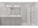 Modern bathroom featuring double vanity, framed mirror, shower with glass doors, and neutral color palette at 18029 Dandy Brush Ln, Parker, CO 80134