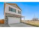 Two-story home with stone accents, two-car garage, and a charming porch, set against a clear blue sky at 18029 Dandy Brush Ln, Parker, CO 80134