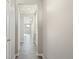 Bright hallway with sleek gray wood floors, leading to sunlit rooms, showcasing modern design elements at 18029 Dandy Brush Ln, Parker, CO 80134