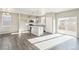 Modern kitchen with stainless appliances, an island, and gray wood floors, open to the living area at 18029 Dandy Brush Ln, Parker, CO 80134
