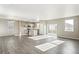 Open-concept living room and kitchen featuring modern gray wood floors and ample natural light at 18029 Dandy Brush Ln, Parker, CO 80134