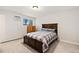 Cozy bedroom featuring a comfortable bed with a gray-and-red plaid pattern and plush carpet at 10150 E Virginia Ave # 104, Denver, CO 80247