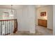 Hallway with decorative railing, paneled walls, and access to bedrooms and built-in cabinetry at 3211 Westbrook Ln, Highlands Ranch, CO 80129