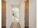 Hallway with carpeted floors leading to the bathroom featuring closets on both sides at 3211 Westbrook Ln, Highlands Ranch, CO 80129