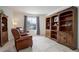 Cozy living room featuring plush leather chairs, built-in wooden bookshelves, and a bright window at 3211 Westbrook Ln, Highlands Ranch, CO 80129