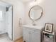 Bright bathroom with modern vanity, round mirror and stylish light fixture at 1888 S Filbert Ct, Denver, CO 80222