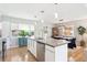 Modern kitchen featuring an island, stainless steel appliances, and an open dining area at 1888 S Filbert Ct, Denver, CO 80222