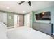 Spacious main bedroom featuring a large mounted television and stylish sliding barn door to bathroom at 1888 S Filbert Ct, Denver, CO 80222