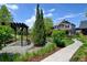 Landscaped backyard featuring a pergola with bench seating, manicured lawn, and mature evergreens at 5080 Uinta St, Denver, CO 80238