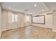 Spacious finished basement with wood-look floors, recessed lighting, projector, and a screen for entertainment at 5080 Uinta St, Denver, CO 80238