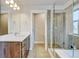Well-lit bathroom featuring custom wood cabinets, and a clear glass shower at 5080 Uinta St, Denver, CO 80238