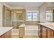 A beautifully designed bathroom features custom wood cabinets and an elegant bathtub at 5080 Uinta St, Denver, CO 80238