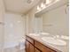 Functional bathroom featuring dual sinks, white tiled walls, vanity and a shower-tub combination at 5080 Uinta St, Denver, CO 80238