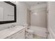 Modern bathroom with white vanity, decorative mirror, toilet, and tiled shower-tub combination at 5080 Uinta St, Denver, CO 80238