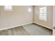 Bright bedroom with neutral walls, carpet floors, white trim, and a door, windows covered with white shutters at 5080 Uinta St, Denver, CO 80238