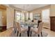 Bright dining room with a glass table, modern chandelier, and plantation shutters at 5080 Uinta St, Denver, CO 80238