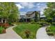 Expansive front yard featuring a pathway, lush lawn, mature trees, and manicured garden beds at 5080 Uinta St, Denver, CO 80238