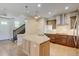 Kitchen featuring a granite island, gas range, custom cabinets, and adjacent stairway at 5080 Uinta St, Denver, CO 80238