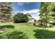 Expansive backyard featuring a lush green lawn, mature trees, and attractive brickwork landscaping features at 8720 E 163Rd Pl, Brighton, CO 80602