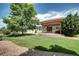 Backyard showcasing a pergola and patio, surrounded by green grass and lush mature trees at 8720 E 163Rd Pl, Brighton, CO 80602