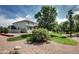 Beautifully landscaped backyard with lush green grass, mature trees, and a charming patio area at 8720 E 163Rd Pl, Brighton, CO 80602