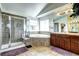Bright bathroom featuring a glass enclosed shower, soaking tub, and wood vanity with large mirror at 8720 E 163Rd Pl, Brighton, CO 80602