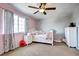 Charming bedroom with a ceiling fan, window with curtains, and white furniture set against pink and gray walls at 8720 E 163Rd Pl, Brighton, CO 80602