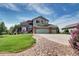 Two-story home with well-maintained lawn, three-car garage and manicured rock-lined driveway at 8720 E 163Rd Pl, Brighton, CO 80602