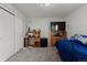 Cozy bedroom featuring neutral walls, carpet floors, and a desk setup with mounted television at 603 Jewel St, Brighton, CO 80603