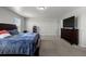 Primary bedroom showcasing neutral walls, plush carpet, and a dark wood dresser at 603 Jewel St, Brighton, CO 80603