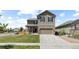 Inviting two-story home boasts a covered porch, an attached two car garage, and manicured front lawn at 603 Jewel St, Brighton, CO 80603